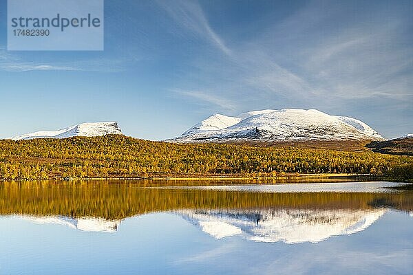 Verschneite Berggruppe Lapporten spiegelt sich im See Vuolio Njáhkájávri  herbstliche Landschaft  Abisko Nationalpark  Lappland  Schweden  Europa