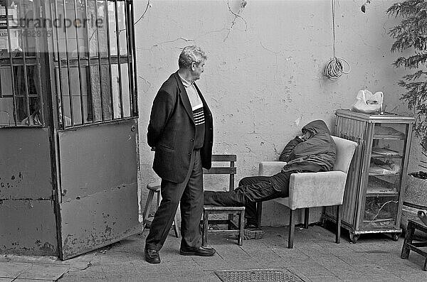 Mann blickt auf Schlafenden im Sessel  Müdigkeit  Schlafpause  im Sessel eingenickt  Mann mit Kapuze in Sessel  Istanbul  Bosporos  Türkei  Asien