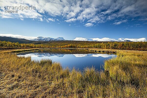 Berggruppe Lapporten und verschneite Berge des Abisko Nationalparks spiegeln sich in kleinem Teich  herbstliche Fjälllandschaft  Abisko  Lappland  Schweden  Europa