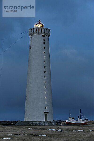 Leuchtturm Garðskagaviti  daneben alter Fischkutter  in der Dämmerung  Garður  Suðurnes  Halbinsel Reykjanes  Island  Europa