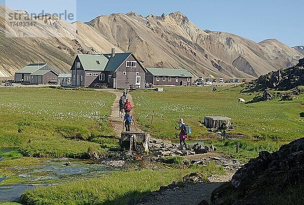 Wanderer auf dem Weg zu einer Hütte  Vulkanberge und grüne Wiesen  Landmannalaugar  Island  Europa