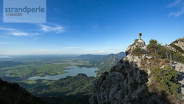 Wanderer auf einem Felsen am Wanderweg  Abendsonne  Gratwanderung Herzogstand Heimgarten  hinten Herzogstand und Kochelsee  Oberbayern  Bayern  Deutschland  Europa