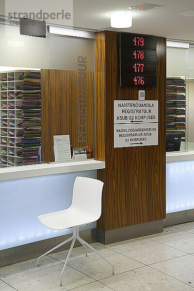 Wartebereich und Empfangsschalter in einem modernen Krankenhaus  mit Schildern und elektronischer Anzeige