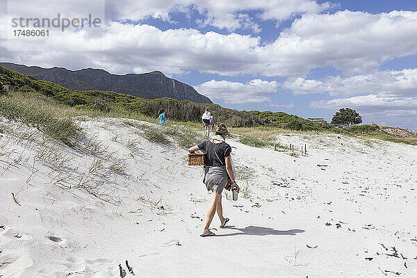 Erwachsene Frau mit Picknickkorb am Grotto Beach  Hermanus  Westkap  Südafrika.