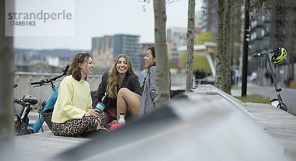 Glückliche junge Frauen unterhalten sich im Stadtpark