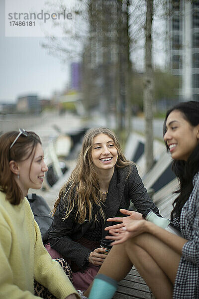 Glückliche junge Frauen  die sich in der Stadt unterhalten