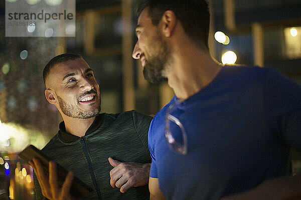 Glückliche Männer männliche Freunde reden nachts