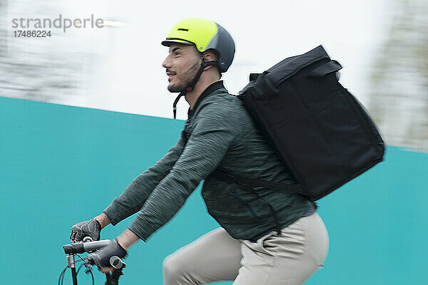 Männlicher Zusteller auf dem Fahrrad mit Tasche