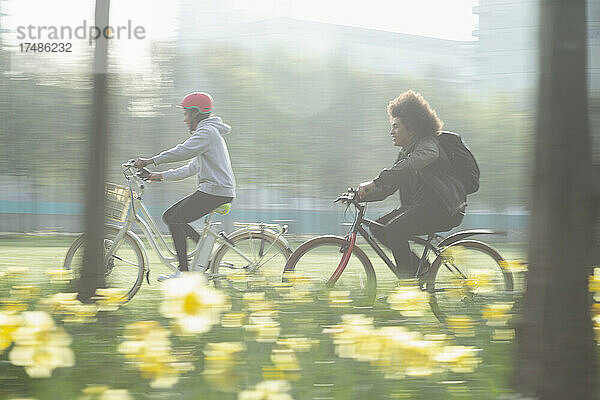 Teenager-Freunde fahren Fahrrad im sonnigen Frühlingspark