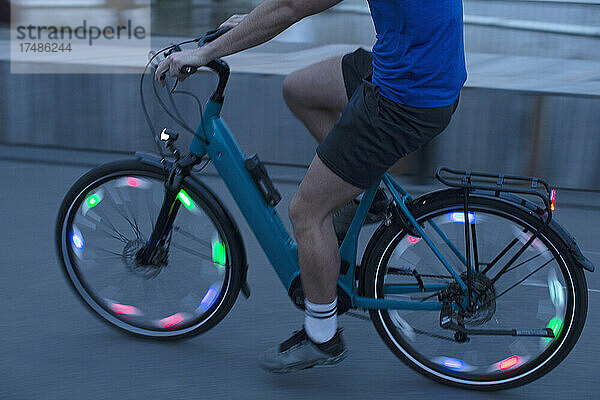 Mann fährt beleuchtetes Fahrrad