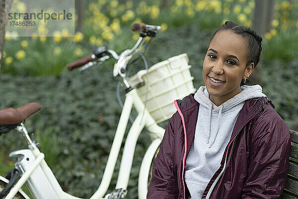 Portrait schöne junge Frau mit Fahrrad im Park