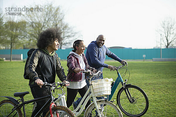 Familie mit Fahrrädern auf einer Parkwiese