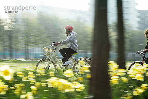 Junge Frau fährt Fahrrad in einem sonnigen Frühlingspark