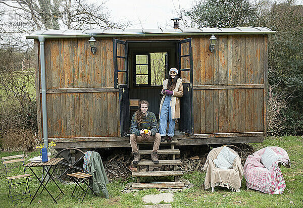 Porträt junges Paar in winziger Hüttenvermietung Türöffnung
