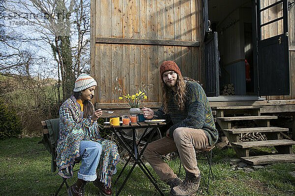 Porträt junges Paar essen am Tisch außerhalb winzige Hütte mieten