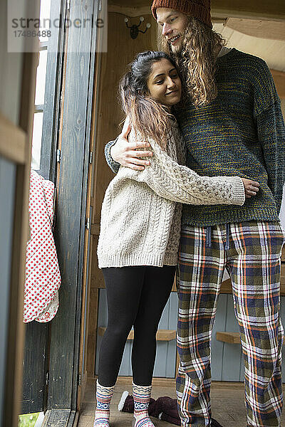 Glückliches junges Paar im Pyjama  das sich umarmt