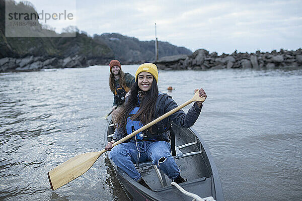 Portrait glückliches junges Paar beim Kanufahren auf einem Fluss