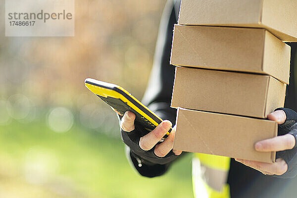 Close up Kurier mit Smartphone bei der Auslieferung von Paketen