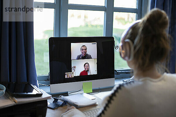 Frau bei Videokonferenz mit Kollegen am Computer im Heimbüro