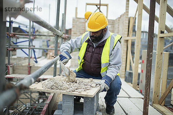 Männlicher Bauarbeiter beim Mischen von Beton auf der Baustelle