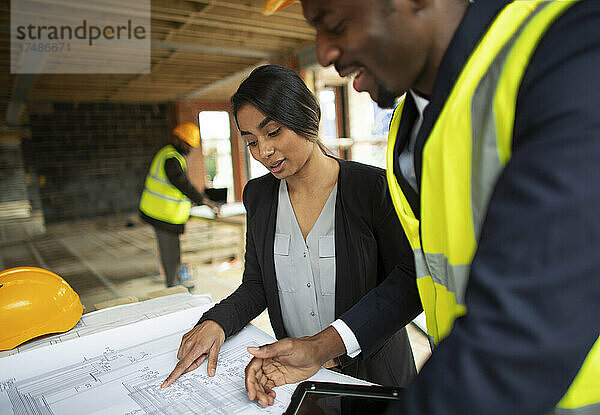 Architekt und Ingenieur bei der Überprüfung von Bauplänen auf der Baustelle