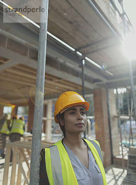 Porträt einer nachdenklichen Bauarbeiterin auf einer Baustelle