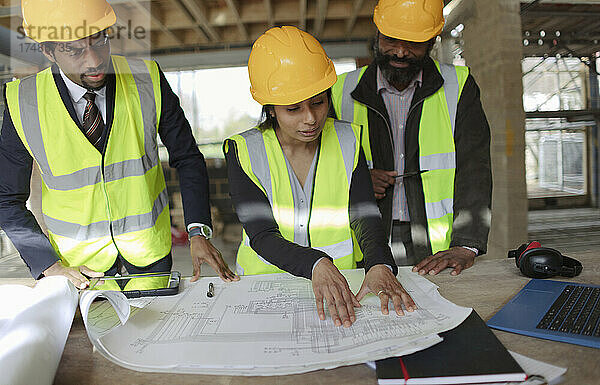 Architekten besprechen Baupläne auf der Baustelle