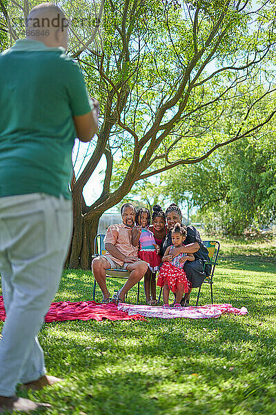 Mann fotografiert Familie im Sommerpark