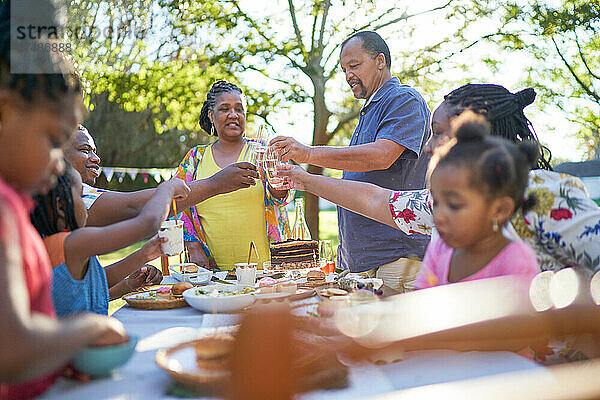 Mehrgenerationenfamilie feiert Geburtstag am sommerlichen Terrassentisch