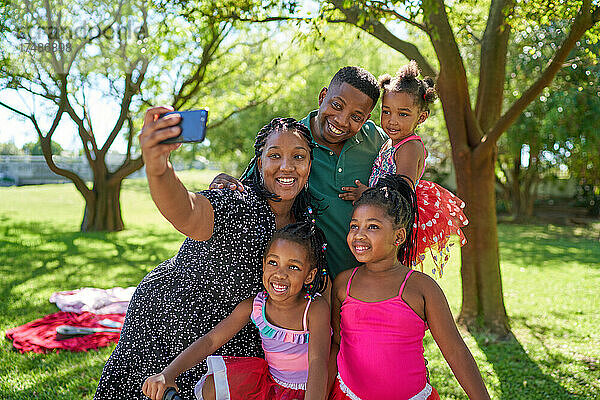 Glückliche Familie nimmt Selfie im Sommer Park