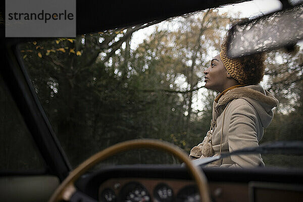 Serene schöne junge Frau außerhalb Cabrio im Herbst Park