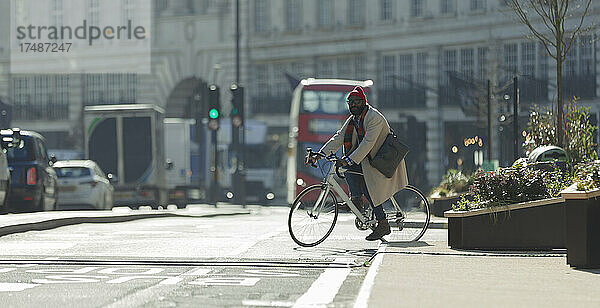 Männlicher Pendler auf dem Fahrrad auf einer sonnigen Straße in London  UK