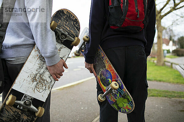 Teenager mit Skateboards auf dem Bürgersteig