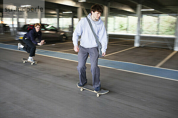 Skateboard fahrende Teenager in einem Parkhaus