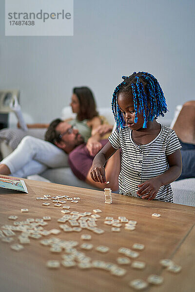 Süßes Kleinkind Mädchen Stapeln Scrabble Fliesen auf Couchtisch