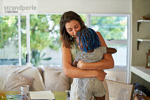 Zärtliche Mutter  die ihre Tochter zu Hause umarmt