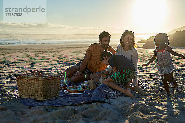 Glückliche Familie bei einem Picknick am sonnigen Sommerstrand