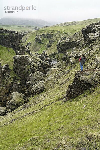 Wanderin in einer Schlucht  Landschaft am Fimmvörðuháls Wanderweg  Südisland  Island  Europa