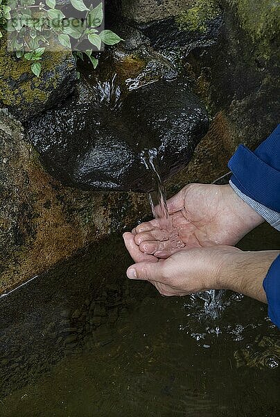 Wanderer wäscht sich die Hände am Brunnen zum Weg nach Rocha da Relva  Insel Sao Miguel  Azoren  Portugal  Europa