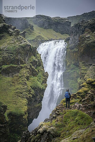 Wanderer an einem Wasserfall in einer Schlucht  Landschaft am Fimmvörðuháls Wanderweg  Südisland  Island  Europa