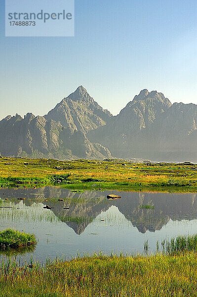 Hohe berge spiegeln sich in einem kleinen See  Blickrichtung Henningsvaer  Vestvågøy  Lofoten  Nordland  Norwegen  Europa