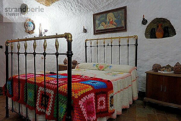 Schlafzimmer mit Heiligenbild über Bett in einer Höhlenwohnung  andalusischer Schlafraum  Guadix  Andalusien  Spanien  Europa