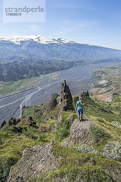 Wanderin blickt über Landschaft  Berge und Gletscherfluss in einem Bergtal  wilde Natur  hinten Gletscher Eyjafjallajökull  Isländisches Hochland  Þórsmörk  Suðurland  Island  Europa