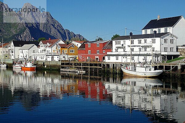 Fischerboote und Häuser spiegeln sich im ruhigen Wasser eines Hafens  Stille  Ruhe  Henningsvaer  Nordland  Lofoten  Norwegen  Europa