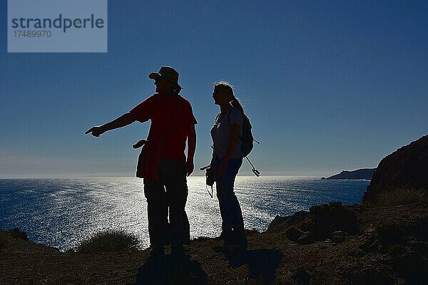 Wanderer an Steilküste im Gegenlicht  Mann und Frau wandern am Meer  Cabo de Gata  Andalusien  Spanien  Europa