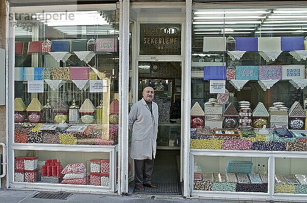Mann im Kittel steht vor seinem Laden mit Süßigkeiten  Ladenbesitzer mit seinen Süßwaren  Eminönü  Istanbul  Türkei  Asien