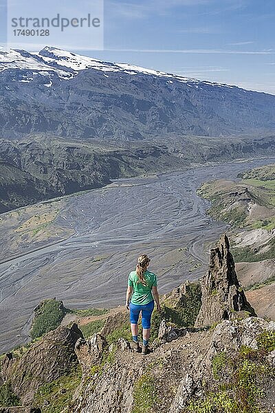 Wanderin blickt über Landschaft  Berge und Gletscherfluss in einem Bergtal  wilde Natur  hinten Gletscher Mýrdalsjökull  Isländisches Hochland  Þórsmörk  Suðurland  Island  Europa