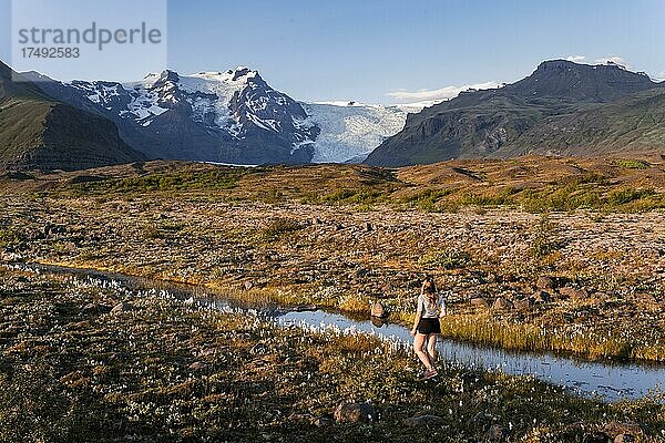 Junge Frau in der Natur  Spiegelung in einem See  Blick auf Gletscherzungen und Berge  Gletscherzungen am Vatnajökull Gletscher  Berg Kristínartindar  Vatnajökull-Nationalpark  Austurland  Island  Europa