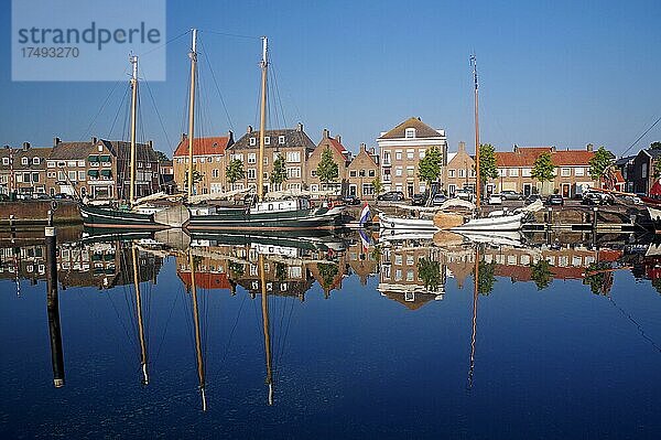 Alte Schiffe und Häuser spiegeln sich im Hafenbecken  Hellevoetsluis  Südholland  Niederlande  Europa