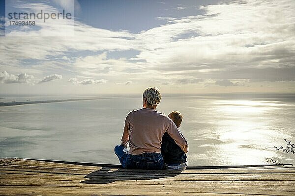 Mutter und 3 Jahre alter Sohn umarmen sich und genießen die schöne Aussicht auf das Meer  Portugal  Europa